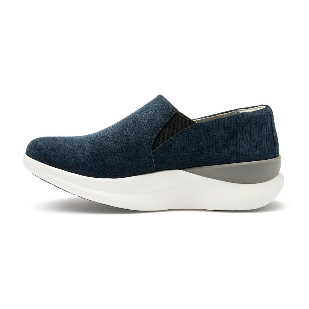 A pair of navy blue suede slip-on shoes with a white sole.